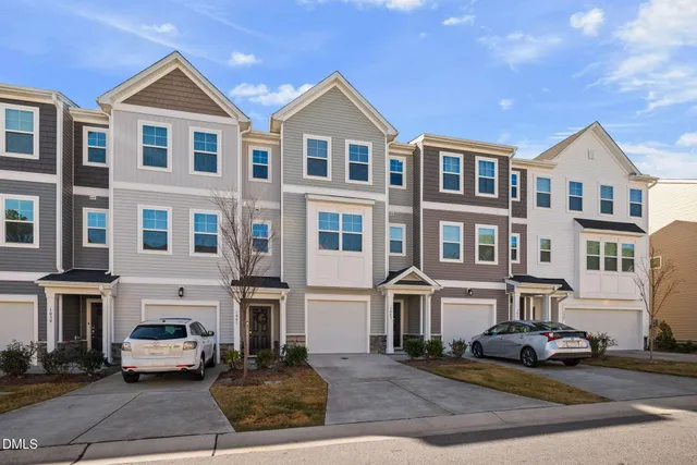 a front view of a residential apartment building with a yard