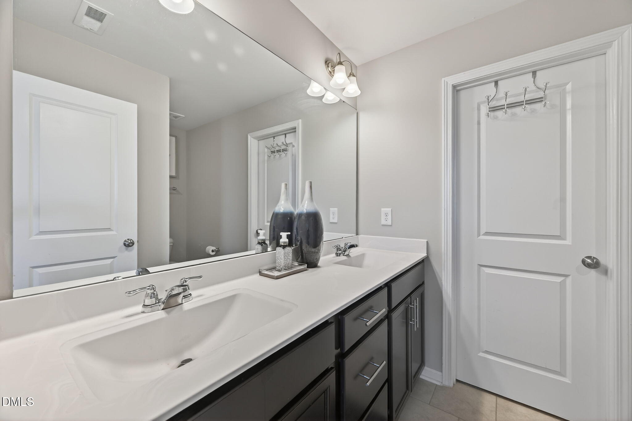 1063 Shoreside Drive Durham, NC 27713 - Photo 24 of 35 a bathroom with double vanity sinks and a mirror