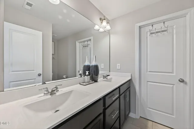 a bathroom with double vanity sinks and a mirror