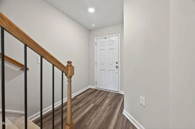 a view of a hallway with wooden floor and entryway