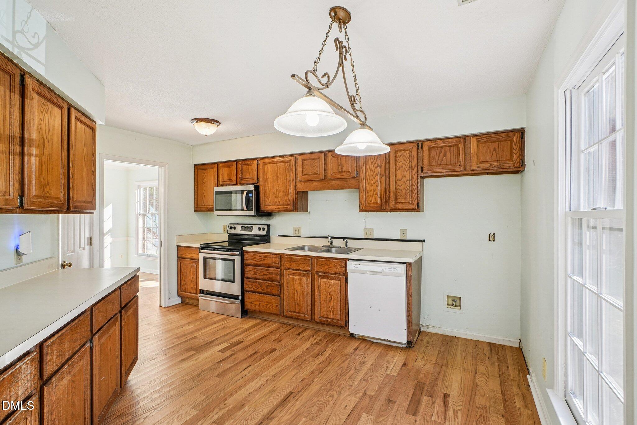 3305 Coachman's Way Durham, NC 27705 - Photo 11 of 35 a kitchen with stainless steel appliances granite countertop wooden floors and sink
