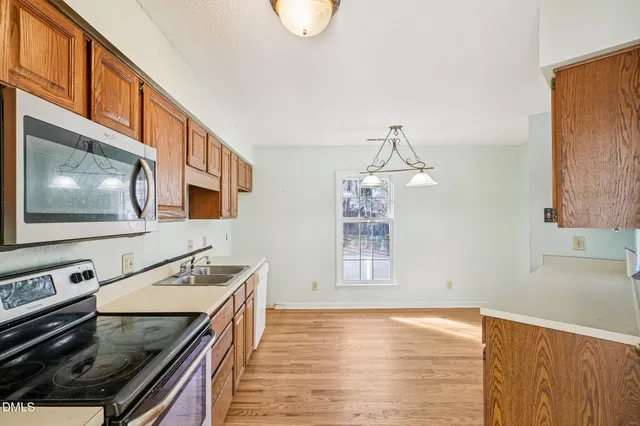 a kitchen with granite countertop a sink and a stove top oven