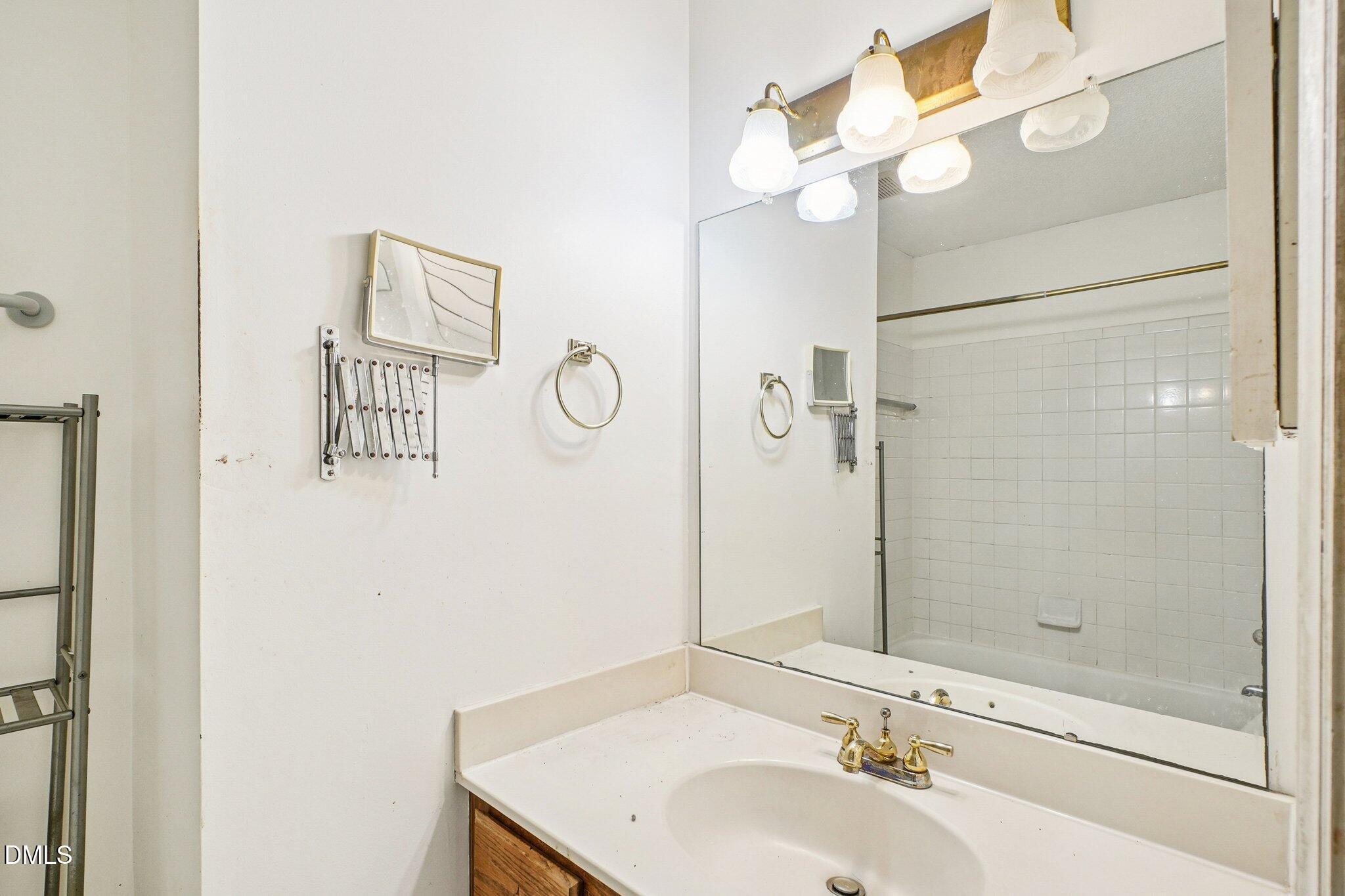 3305 Coachman's Way Durham, NC 27705 - Photo 20 of 35 a bathroom with a sink a mirror and a shower