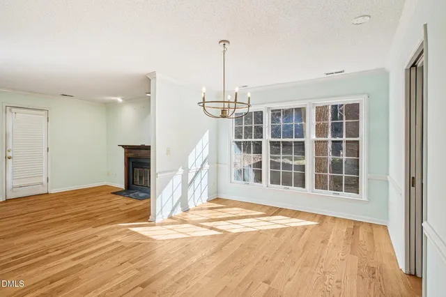 a view of empty room with a window and wooden floor