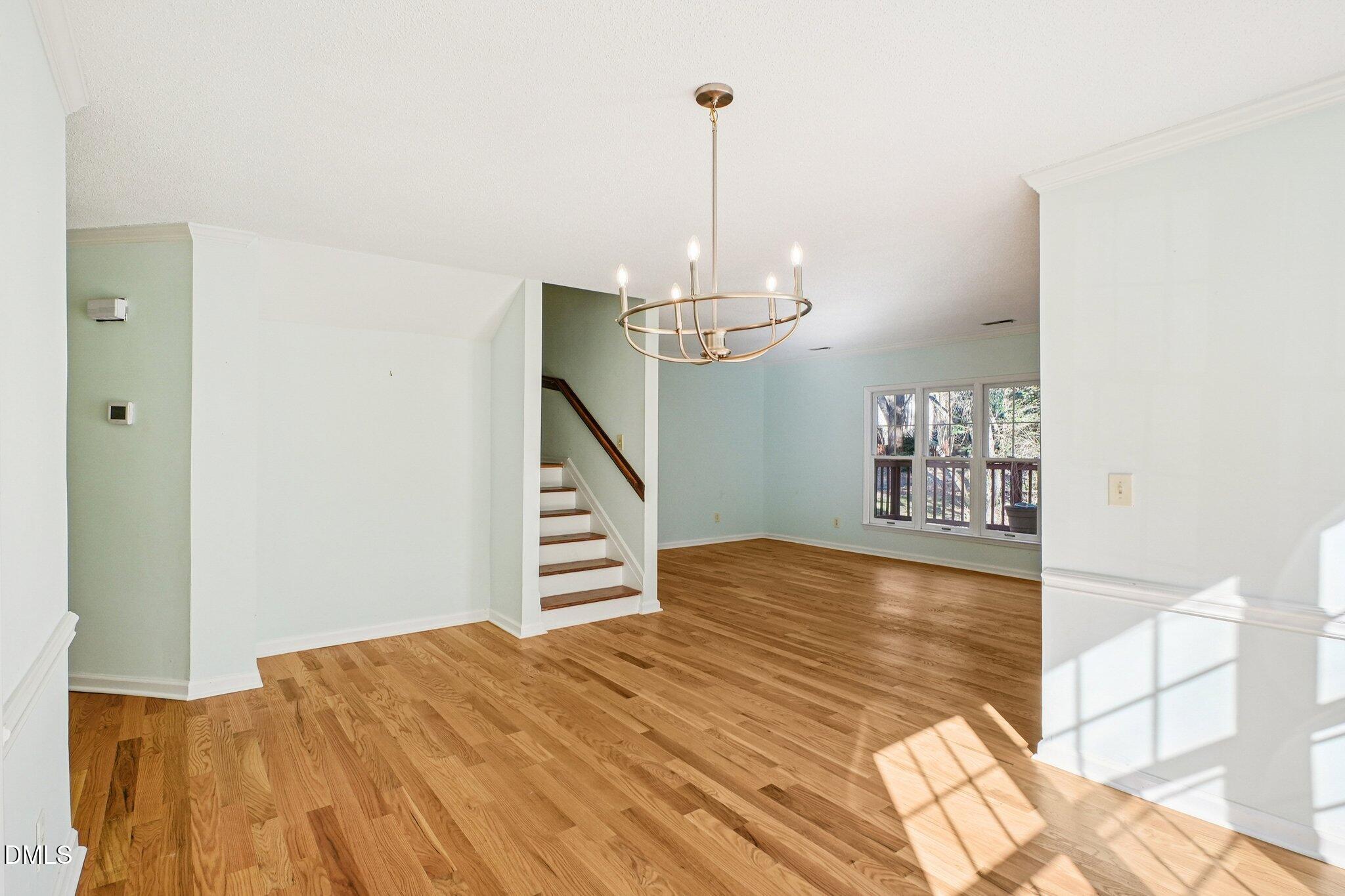 3305 Coachman's Way Durham, NC 27705 - Photo 7 of 35 a view of a room with wooden floor staircase and a kitchen