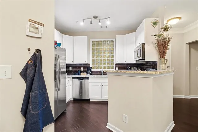 a kitchen with stainless steel appliances a white refrigerator a stove a sink and a chandelier