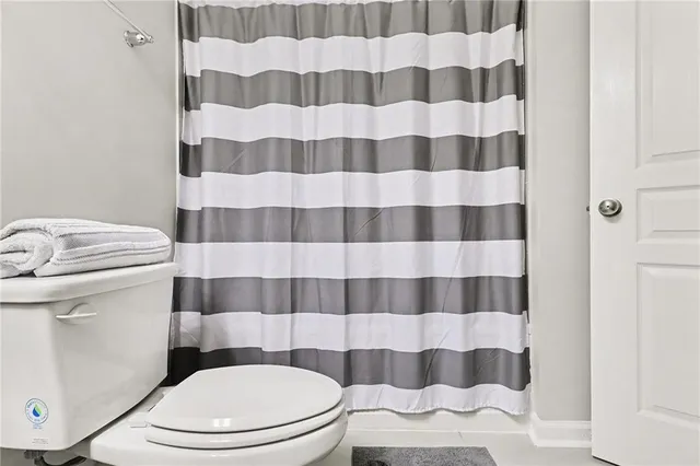 a white toilet sitting next to a shower curtain