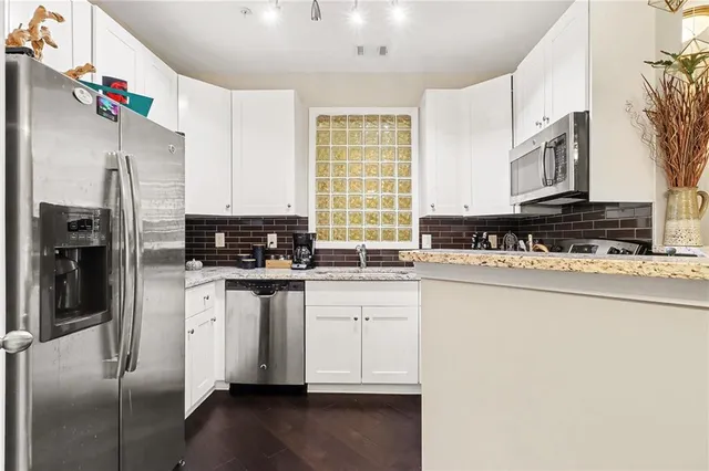 a kitchen with stainless steel appliances granite countertop a stove a sink and a refrigerator