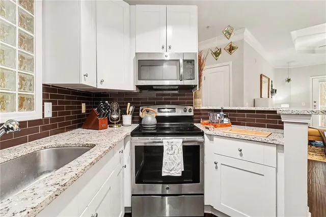 a kitchen with granite countertop a sink stainless steel appliances and cabinets