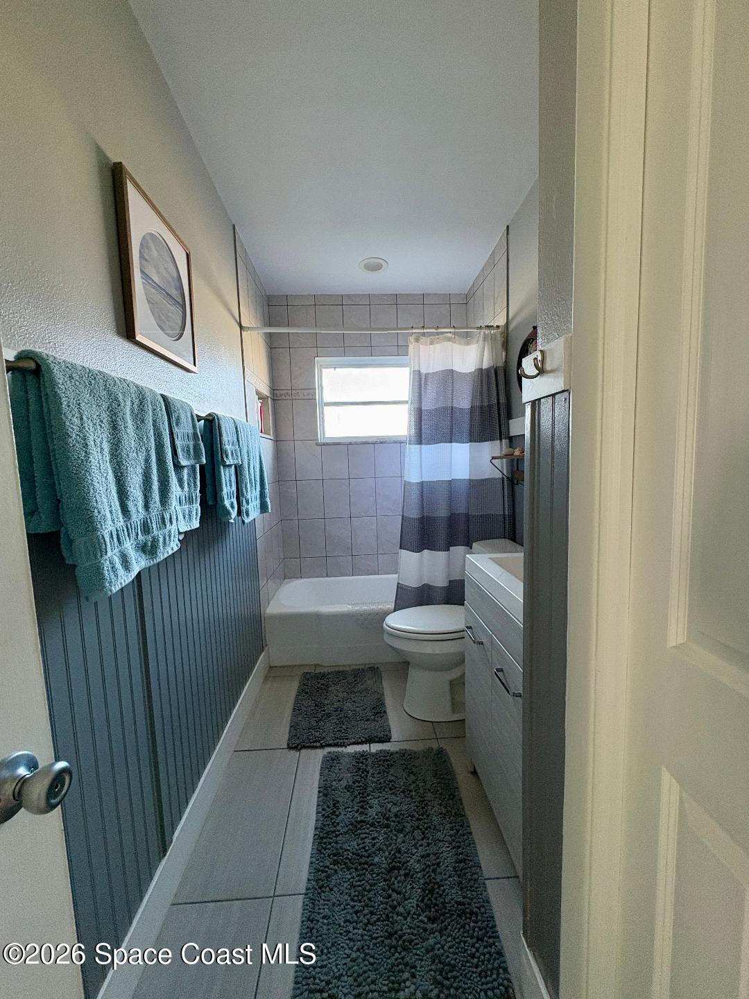 906 Santa Cruz Road Cocoa Beach, FL 32931 - Photo 17 of 24 a bathroom with a toilet a sink and mirror