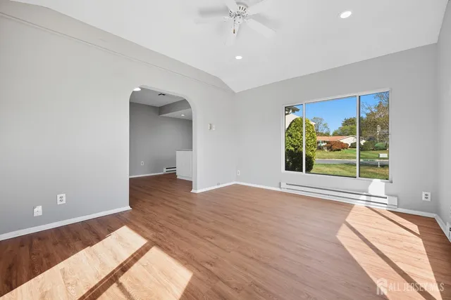 a view of a bedroom with wooden floor and a window