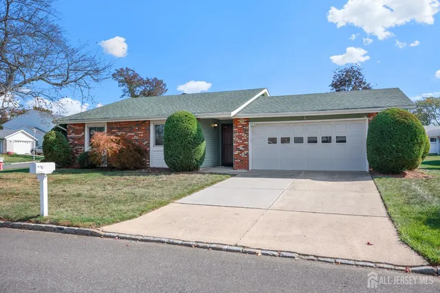 a sign board with flower garden and wooden fence
