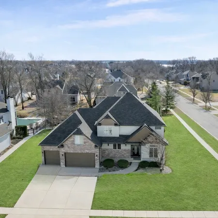 an aerial view of residential houses with outdoor space and trees