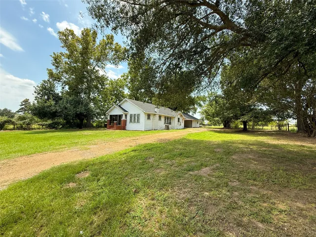a yellow house with trees in front of it