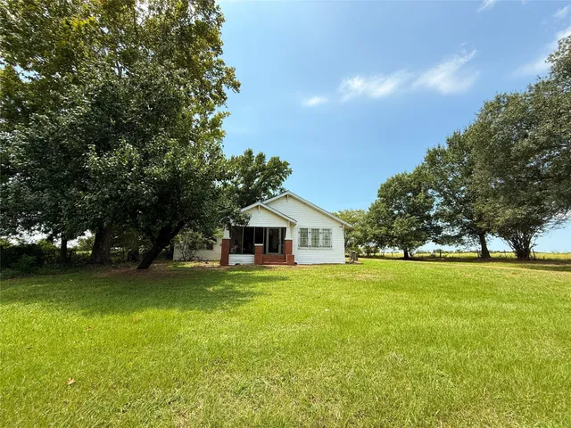 a front view of a house with a garden and yard