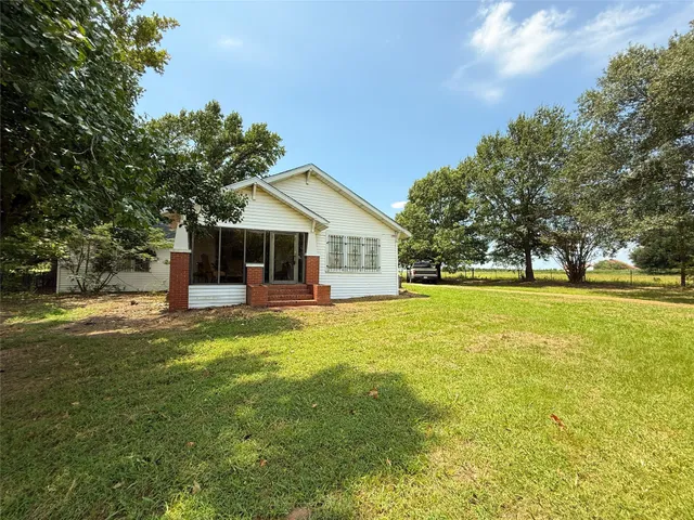 a view of a house with a big yard and a large tree
