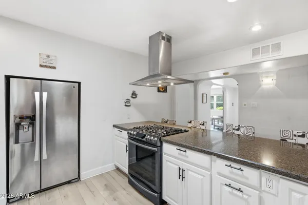 a kitchen with stainless steel appliances granite countertop a sink and refrigerator