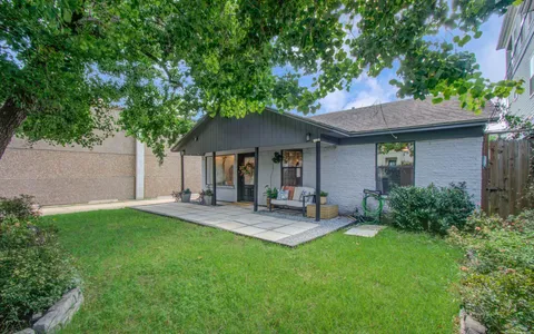 a view of house with backyard and outdoor seating