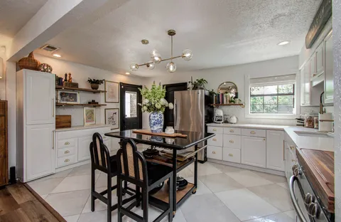 a room with stainless steel appliances kitchen island granite countertop furniture and a refrigerator