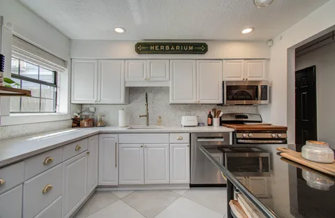 a kitchen with cabinets stainless steel appliances and a window