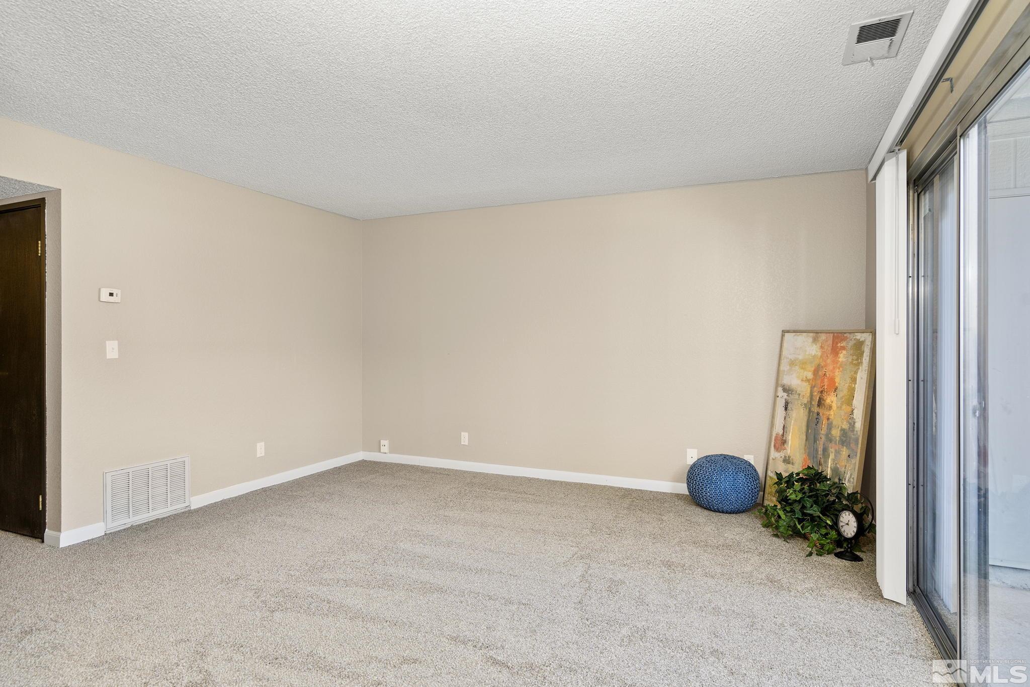 4604 Neil Road, Unit 127 Reno, NV 89502 - Photo 3 of 14 an empty room with wooden floor and closet area