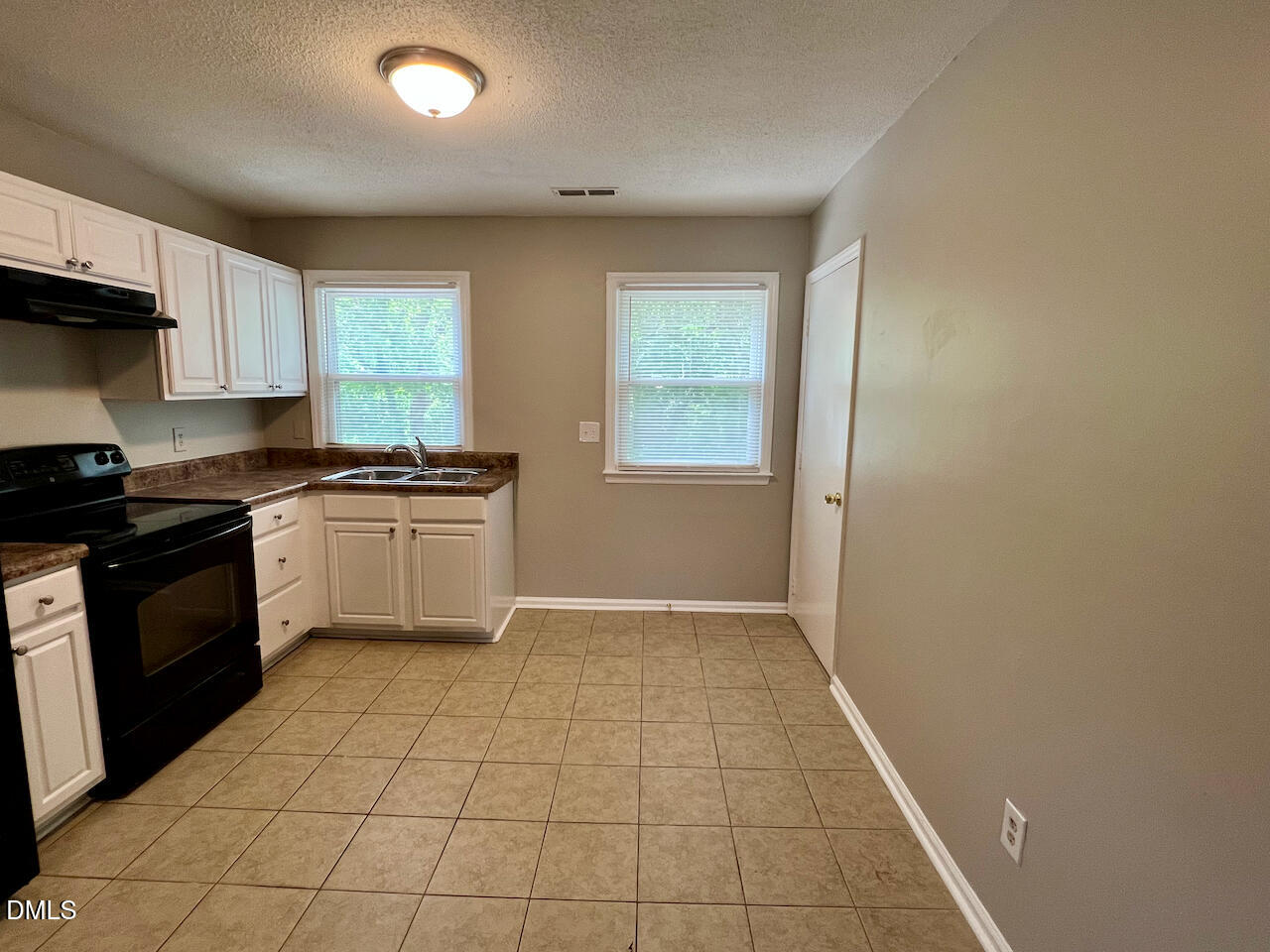 1320 Poole Road, Unit J Raleigh, NC 27610 - Photo 6 of 12 a kitchen with a sink a stove top oven and cabinets
