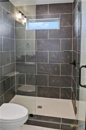 a bathroom with a toilet and a shower