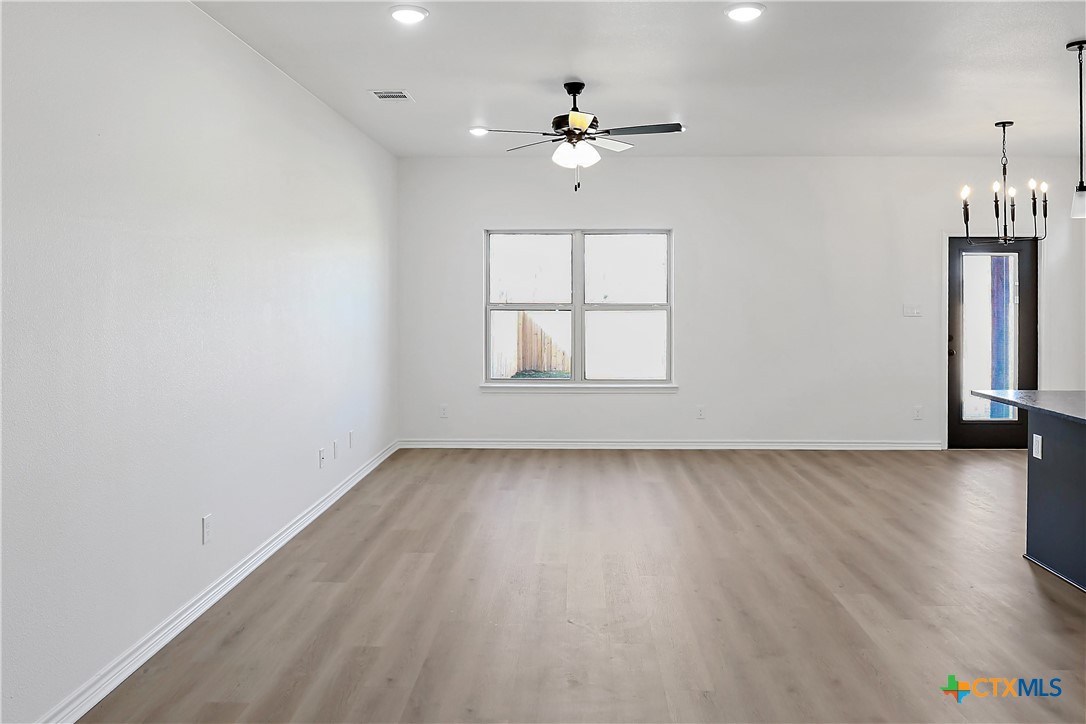 1408 Rita Blanca Court Temple, TX 76502 - Photo 2 of 17 an empty room with windows and chandelier fan