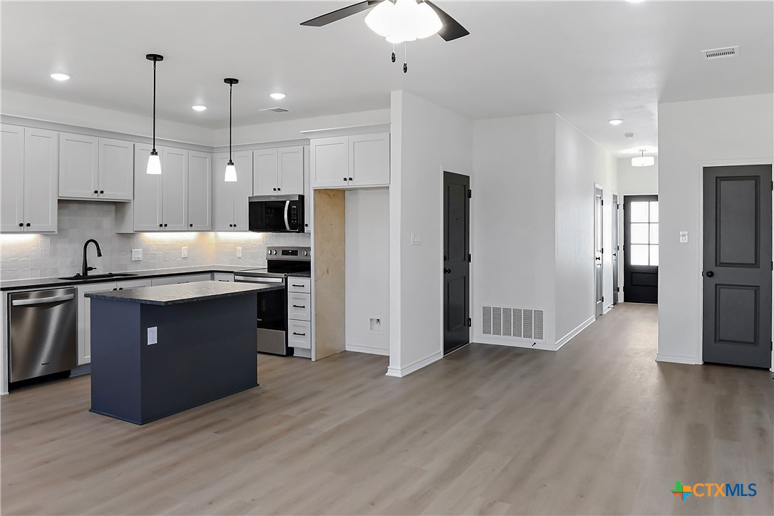 1408 Rita Blanca Court Temple, TX 76502 - Photo 4 of 17 a kitchen with stainless steel appliances granite countertop a refrigerator a sink a stove a microwave and wooden floor