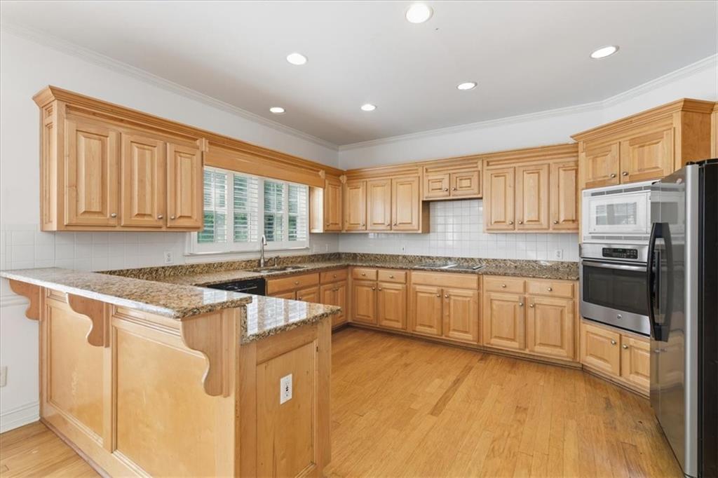 2021 Cockrell Pointe Northwest Kennesaw, GA 30152 - Photo 3 of 54 a kitchen with stainless steel appliances granite countertop a stove a sink dishwasher a refrigerator and white cabinets with wooden floor