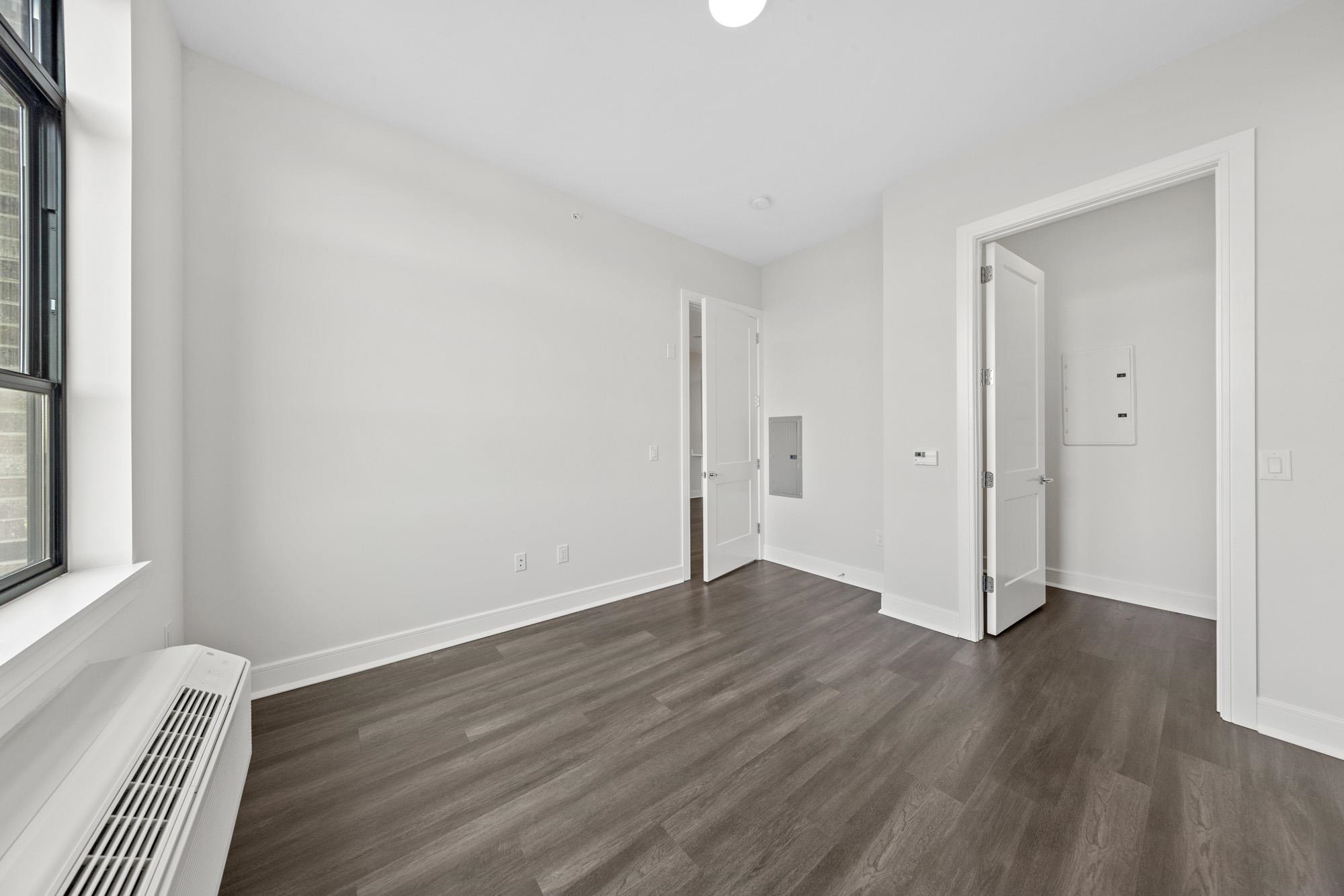 121 34th Street, Unit 604 Union City, NJ 07087 - Photo 12 of 44 a view of a room with wooden floor and a window