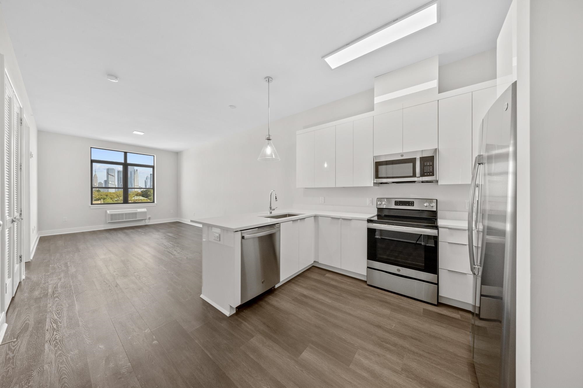 121 34th Street, Unit 604 Union City, NJ 07087 - Photo 4 of 44 a kitchen with a refrigerator and a stove top oven
