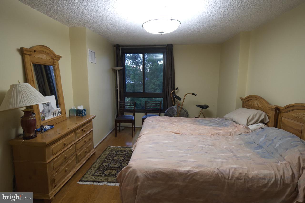 1800 Old Meadow Road, Unit 818 McLean, VA 22102 - Photo 23 of 35 a bedroom with a bed table window and dresser