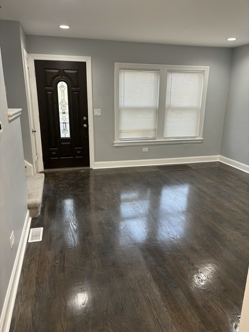 2049 East 93rd Street Chicago, IL 60617 - Photo 4 of 19 an empty room with wooden floor and a window