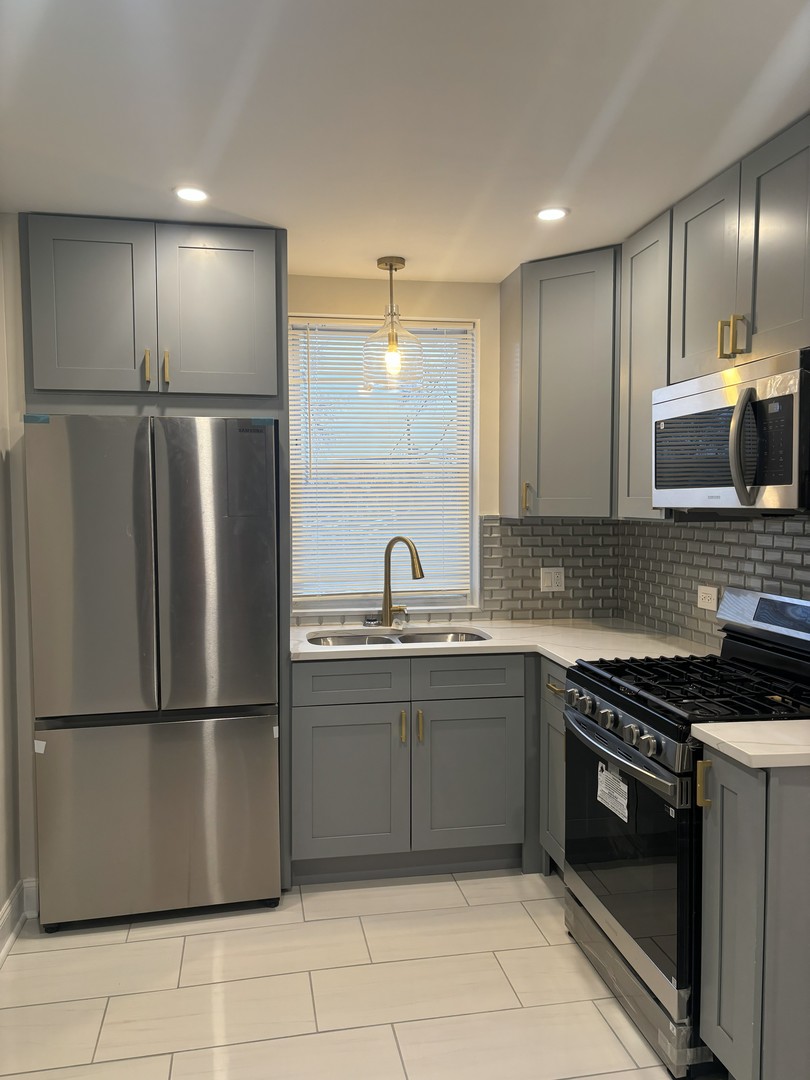 2049 East 93rd Street Chicago, IL 60617 - Photo 5 of 19 a kitchen with stainless steel appliances granite countertop a sink and a refrigerator
