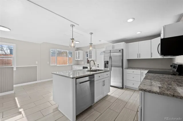 a kitchen with stainless steel appliances granite countertop a sink stove and refrigerator
