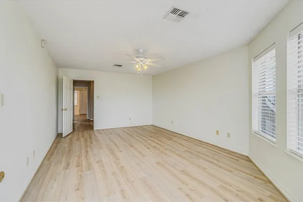 a spacious bedroom with a large bed and a chandelier