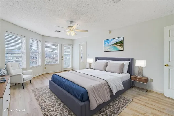 an empty room with wooden floor chandelier fan and windows
