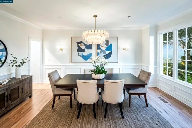 a view of a dining room with furniture a chandelier and wooden floor