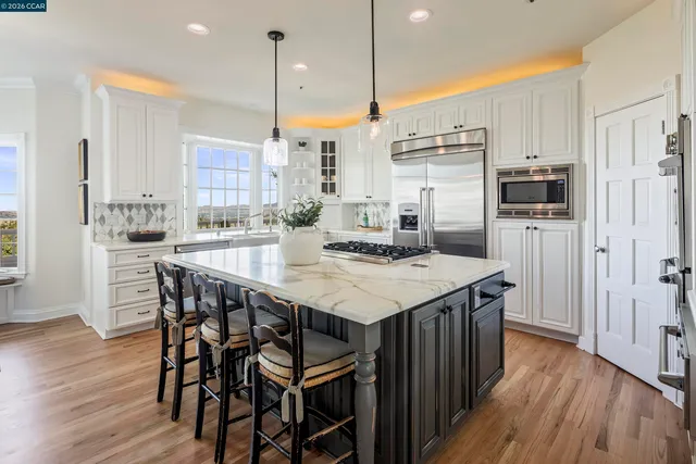 a kitchen with kitchen island a wooden floor and white appliances