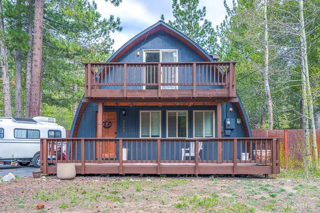 a view of wooden house with a yard and deck