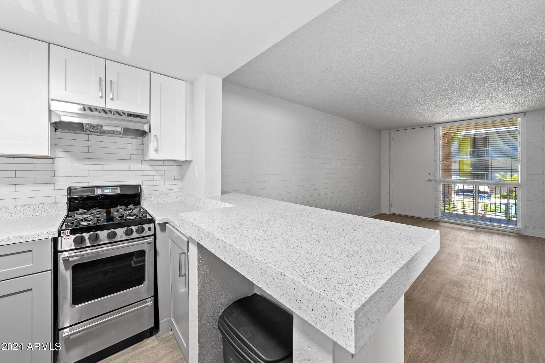 1601 West Camelback Road, Unit E10AE Phoenix, AZ 85015 - Photo 5 of 22 a kitchen with granite countertop a stove and a sink