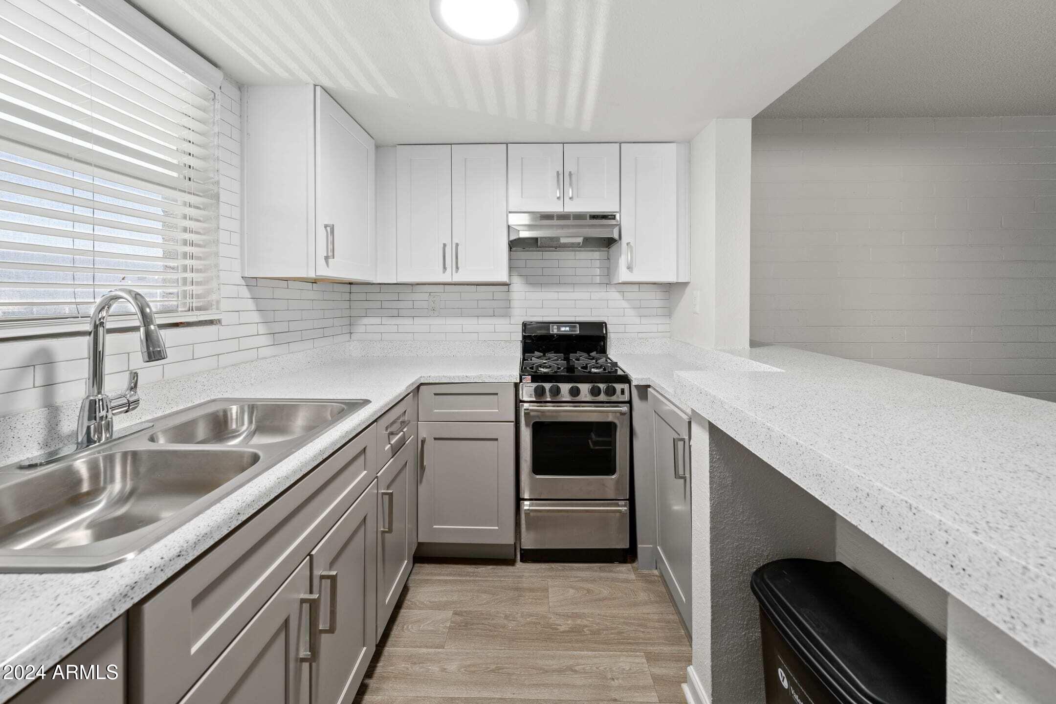 1601 West Camelback Road, Unit E10AE Phoenix, AZ 85015 - Photo 6 of 22 a kitchen with cabinets stainless steel appliances and a sink
