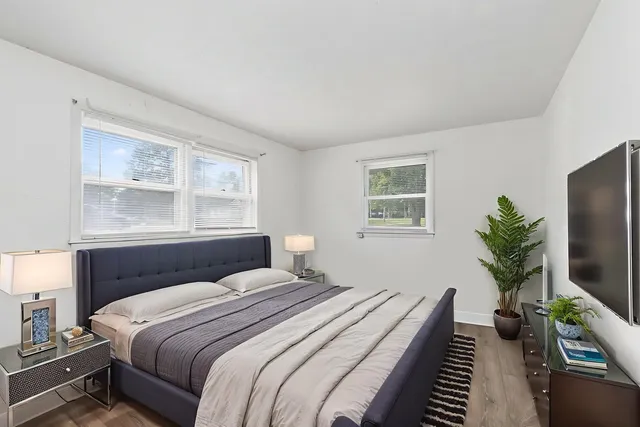 a bedroom with a large bed and a flat tv screen on a dresser
