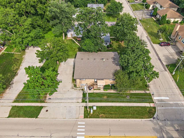 an aerial view of a house with a yard and trees