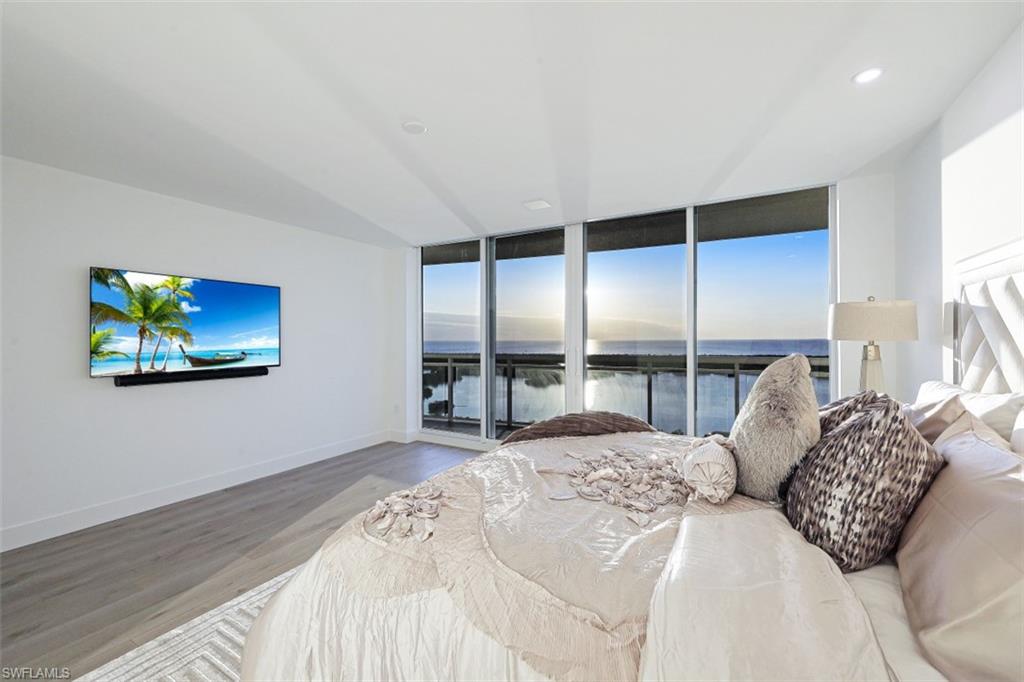 13935 Old Coast Road, Unit 1703 Naples, FL 34110 - Photo 13 of 44 a large bedroom with a bed and a large window