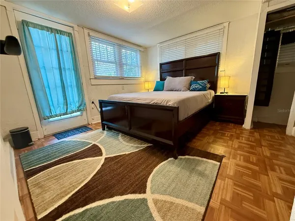 a bedroom with a bed and wooden floor