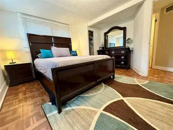 a bedroom with a bed and wooden floor