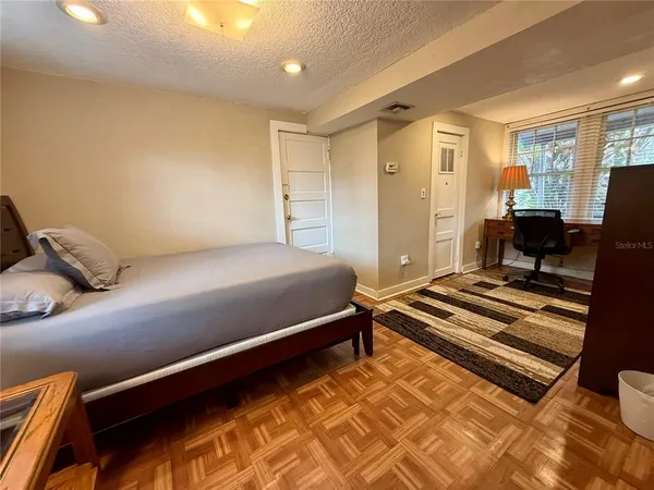 a bedroom with a bed and wooden floor
