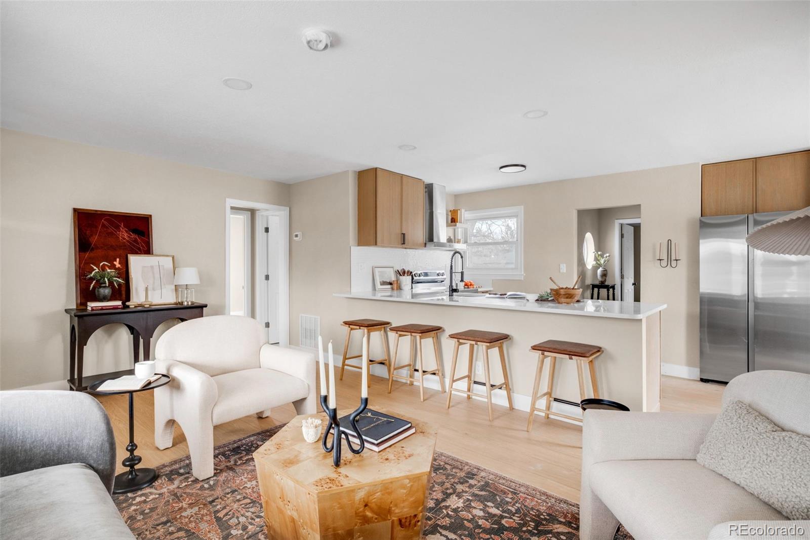 1900 Quebec Street Denver, CO 80220 - Photo 8 of 15 a living room with furniture a rug kitchen view and a large mirror